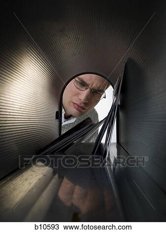 Close-up of a young man looking into a mailbox View Large Photo Image Stock Image - Close-up of a young man looking into a mailbox. Fotosearch