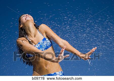 Close-up of a young woman getting sprayed with water View Large Photo Image Stock Photo - Close-up of a young woman getting sprayed with water. Fotosearch