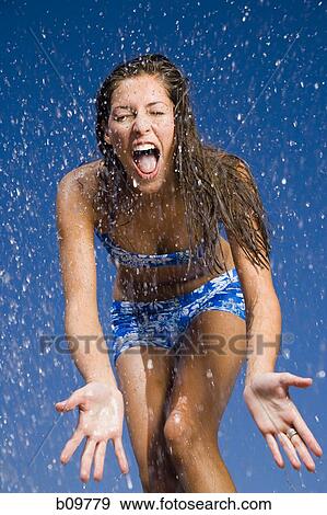 Close-up of a young woman getting sprayed with water View Large Photo Image Stock Photo - Close-up of a young woman getting sprayed with water. Fotosearch