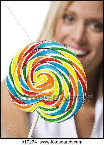 Close-up of a young woman holding a lollipop View Large Photo Image Picture - Close-up of a young woman holding a lollipop. Fotosearch