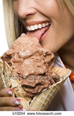 Close-up of a young woman licking an ice-cream cone View Large Photo Image Picture - Close-up of a young woman licking an ice-cream cone. Fotosearch