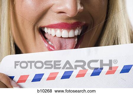 Close-up of a young woman licking an envelope View Large Photo Image Stock Photo - Close-up of a young woman licking an envelope. Fotosearch