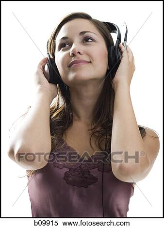 Stock Photography - Close-up of a young woman listening to music on headphones. Fotosearch