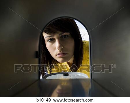 Stock Photo - Close-up of a young woman looking at an empty mailbox. Fotosearch