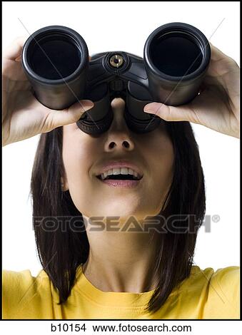 Close-up of a young woman looking through a pair of binoculars View Large Photo Image Picture - Close-up of a young woman looking through a pair of binoculars. Fotosearch
