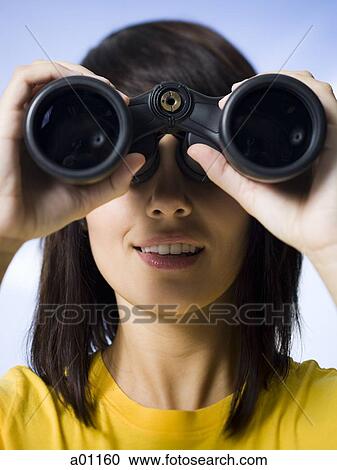 Close-up of a young woman looking through a pair of binoculars View Large Photo Image Stock Image - Close-up of a young woman looking through a pair of binoculars. Fotosearch