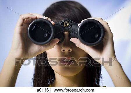 Close-up of a young woman looking through a pair of binoculars View Large Photo Image Stock Image - Close-up of a young woman looking through a pair of binoculars. Fotosearch