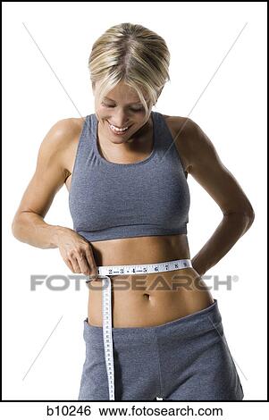 Close-up of a young woman measuring her waist with a measuring tape View Large Photo Image Stock Photograph - Close-up of a young woman measuring her waist with a measuring tape. Fotosearch