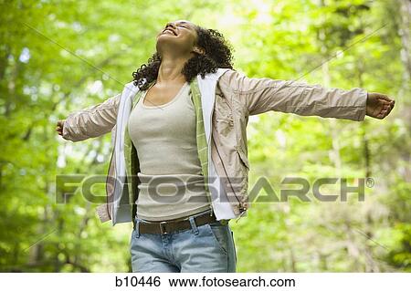 Close-up of a young woman with her arms outstretched View Large Photo Image Stock Photograph - Close-up of a young woman with her arms outstretched. Fotosearch