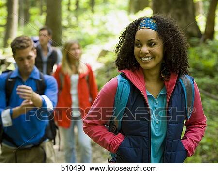 Close-up of a young woman with her friends in the background View Large Photo Image Stock Image - Close-up of a young woman with her friends in the background. Fotosearch