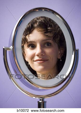 Close-up of a young woman's reflection in a mirror View Large Photo Image Stock Image - Close-up of a young woman's reflection in a mirror. Fotosearch
