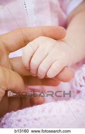 Close-up of baby girl's hand holding finger View Large Photo Image Stock Image - Close-up of baby girl's hand holding finger. Fotosearch