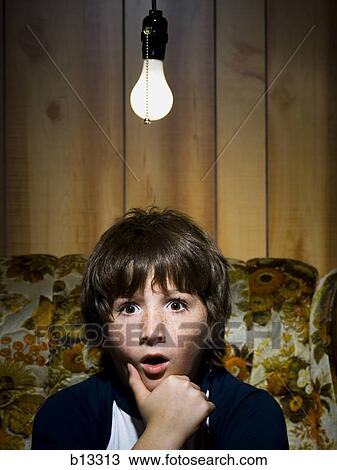 Stock Image - Close-up of boy with light bulb . Fotosearch