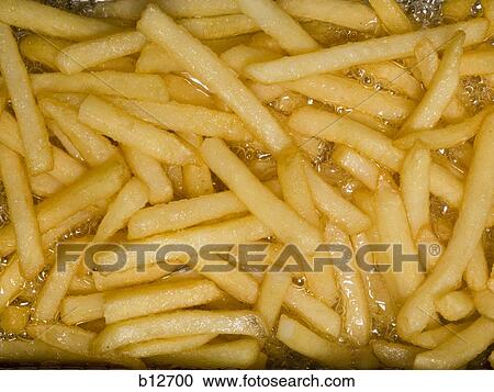 Stock Image - Close-up of French fries cooking. Fotosearch