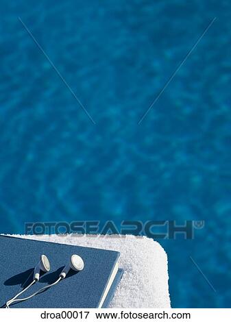 Close-up of headphones with a book on a towel View Large Photo Image Stock Photo - Close-up of headphones with a book on a towel. Fotosearch