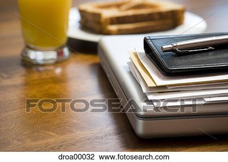 Stock Image - Close-up of laptop daytimer and papers on desk. Fotosearch