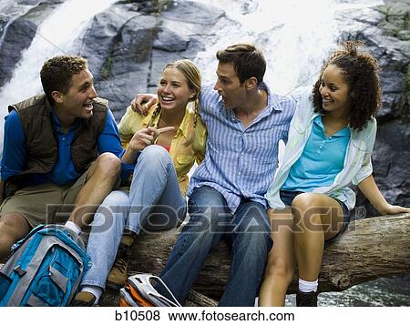 Close-up of two young women and two young men talking to each other View Large Photo Image Stock Photo - Close-up of two young women and two young men talking to each other. Fotosearch
