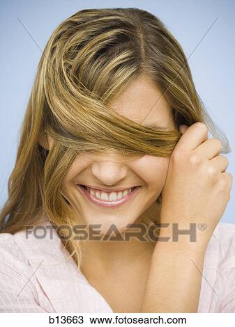 Closeup of smiling woman hiding eyes with hair View Large Photo Image Stock Image - Closeup of smiling woman hiding eyes with hair. Fotosearch