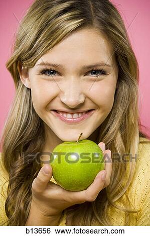 Closeup of woman smiling with green apple View Large Photo Image Stock Photograph - Closeup of woman smiling with green apple. Fotosearch
