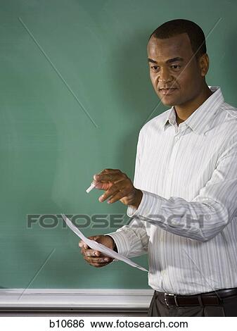 Stock Photograph - College teacher giving a lesson in classroom. Fotosearch