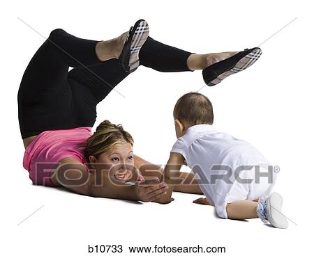 Stock Image - Contortionist mother with baby daughter. Fotosearch