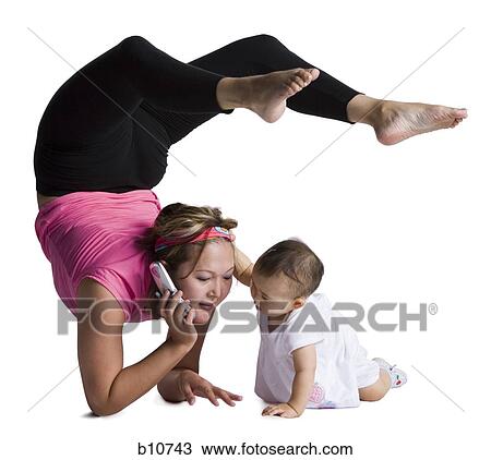Stock Image - Contortionist mother with baby daughter. Fotosearch