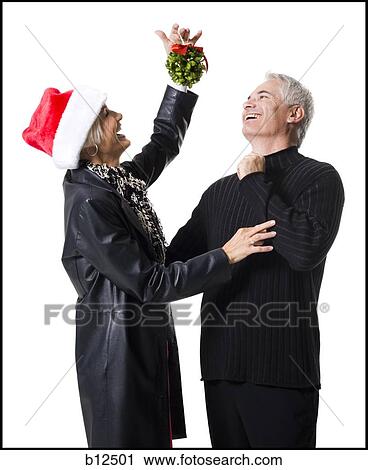 Stock Image - Couple celebrating Christmas with mistletoe. Fotosearch