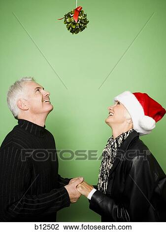 Stock Image - Couple celebrating Christmas with mistletoe. Fotosearch