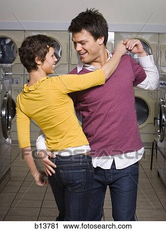 Stock Image - Couple dancing in Laundromat. Fotosearch