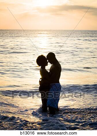 Stock Photograph - Couple embracing on beach. Fotosearch
