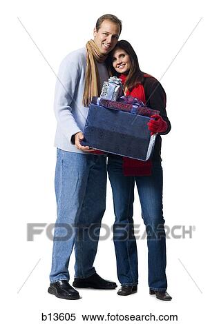 Couple embracing with Christmas gifts View Large Photo Image Stock Photography - Couple embracing with Christmas gifts. Fotosearch