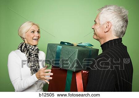 Stock Photography - Couple exchanging Christmas presents. Fotosearch