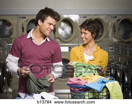 Couple folding laundry in Laundromat View Large Photo Image Picture - Couple folding laundry in Laundromat. Fotosearch