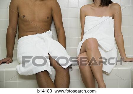 Stock Image - Couple in sauna with towels from neck down. Fotosearch