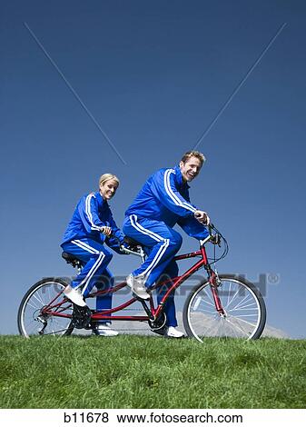 Stock Photo - Couple riding on a tandem bicycle. Fotosearch
