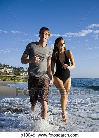 Stock Photography - Couple running on a beach. Fotosearch