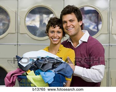 Couple with clothing in laundry basket at Laundromat smiling View Large Photo Image Stock Photography - Couple with clothing in laundry basket at Laundromat smiling. Fotosearch