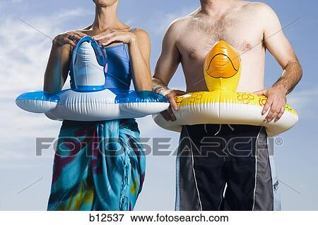 Stock Photo - Couple with swimming rings around waist. Fotosearch