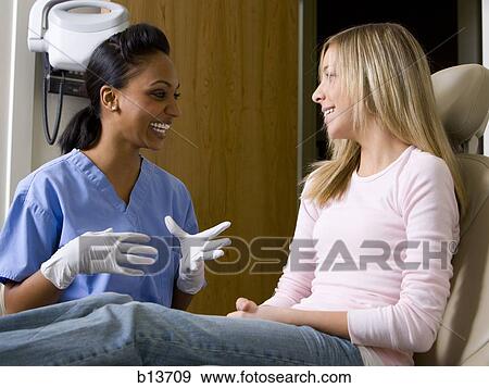 Dental hygienist talking to girl View Large Photo Image Stock Photo - Dental hygienist talking to girl. Fotosearch