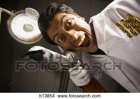 Picture - Dentist with drill dramatic angle. Fotosearch