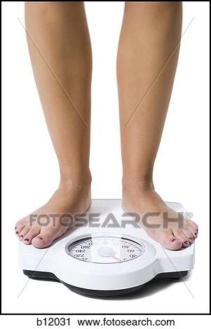 Dieting woman standing on bathroom scale View Large Photo Image Stock Image - Dieting woman standing on bathroom scale. Fotosearch