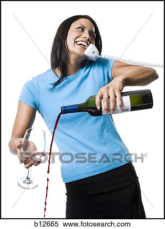 Stock Photography - Distracted woman pouring red wine and missing glass. Fotosearch