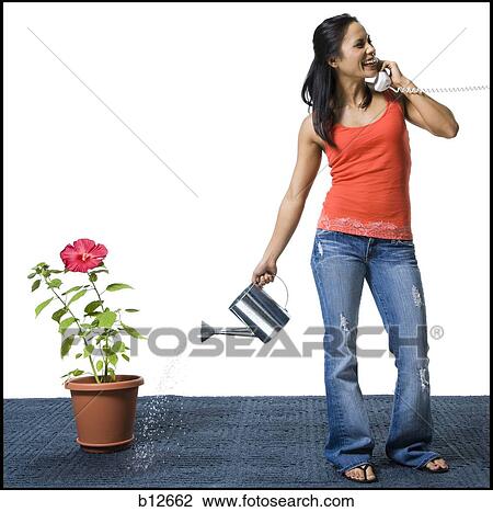 Distracted woman watering flowers but missing the pot View Large Photo Image Stock Image - Distracted woman watering flowers but missing the pot. Fotosearch