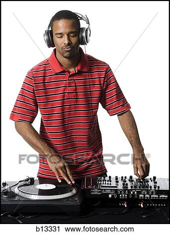 DJ with headphones spinning records View Large Photo Image Stock Image - DJ with headphones spinning records. Fotosearch