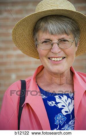 Stock Image - Elderly woman in a straw hat. Fotosearch