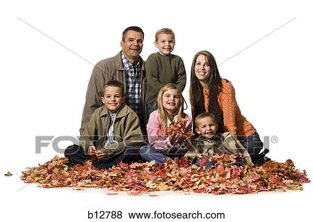 Stock Photo - Family posing in a pile of fallen leaves. Fotosearch