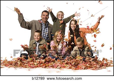 Stock Photo - Family posing in a pile of fallen leaves. Fotosearch