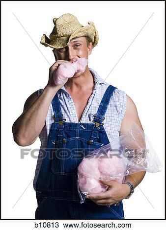 Stock Image - Farmer eating cotton candy. Fotosearch