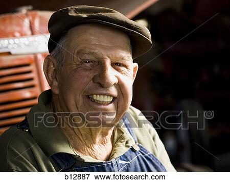 Farmer posing with his tractor View Large Photo Image Stock Photo - Farmer posing with his tractor. Fotosearch