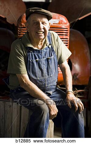 Farmer posing with his tractor View Large Photo Image Stock Photography - Farmer posing with his tractor. Fotosearch